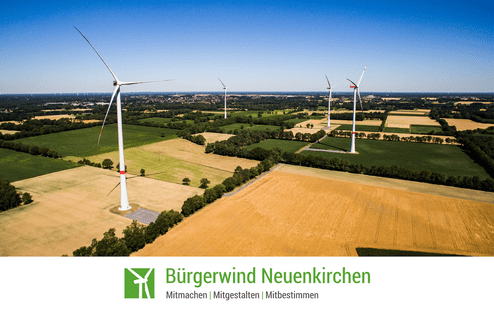 Luftaufnahme von Windkraftanlagen in einer weitläufigen ländlichen Landschaft mit Ackerflächen.